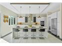 Bright, modern kitchen features a waterfall island with seating, stainless steel appliances, and stylish pendant lighting at 14124 Eliot Ave, Orlando, FL 32827
