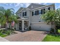 Stylish two-story house showcases a brick driveway and lush landscaping at 14193 Gold Bridge Dr, Orlando, FL 32824