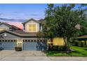 Charming two-story home featuring an attached two-car garage and a well-manicured front yard during twilight at 1461 Travertine Ter, Sanford, FL 32771