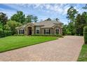 Attractive single-story home with stone accents, mature trees and a brick driveway at 1462 Palm Bay Ct, Lake Mary, FL 32746