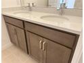 Close-up of a bathroom double vanity with white countertop and modern silver faucets at 2043 Town Pasture Dr, Eustis, FL 32726