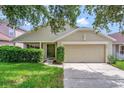 Beige home with green door, lawn, mature landscaping, and attached one car garage at 2081 Newtown Rd, Groveland, FL 34736