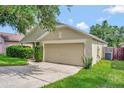 Tan home with one car garage, green grass, and landscaping at 2081 Newtown Rd, Groveland, FL 34736