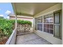Cozy covered front porch with white railing and window with dark shutters at 2081 Newtown Rd, Groveland, FL 34736