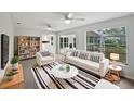 Bright living room with white sofa, decorative rug, ceiling fans, and view to backyard at 215 Rydalmont Rd, Winter Haven, FL 33884