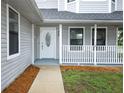 Inviting front porch with white railings and a decorative glass front door at 2304 Harding Cir, Deltona, FL 32738