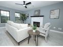 Cozy living room with a fireplace, large windows, and modern furnishings at 2304 Harding Cir, Deltona, FL 32738