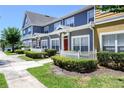 Townhome exterior showcasing colorful facade, white picket fence, and manicured green landscaping at 2605 Gala S Rd # 106, Kissimmee, FL 34746