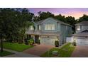 Inviting two-story home featuring a manicured lawn, paver driveway, and attached two-car garage at 2621 Peony Dr, Oviedo, FL 32766