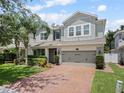 Charming two-story home with a brick driveway, well-manicured lawn, and a two car garage at 2621 Peony Dr, Oviedo, FL 32766