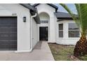 A beautiful front door entrance with arched detailing and well-manicured landscaping leads guests to this charming home at 2639 Monaco Cove Cir, Orlando, FL 32825
