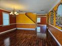 Bright living room with hardwood floors, decorative walls and a chandelier at 438 Janice Kay Pl, Kissimmee, FL 34744