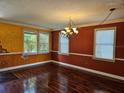 Spacious living room with natural light, hardwood floors, and a decorative chandelier at 438 Janice Kay Pl, Kissimmee, FL 34744