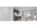 Modern kitchen with stainless steel appliances, dark cabinets, granite countertops, and pendant lighting at 5030 Caspian St, St Cloud, FL 34771
