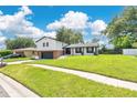 Charming two-story home with a brick and gray two-car garage and beautifully manicured lawn at 614 Mockingbird Ln, Altamonte Springs, FL 32714