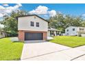 Charming two-story home with a brick and gray two-car garage and beautifully manicured lawn at 614 Mockingbird Ln, Altamonte Springs, FL 32714