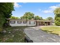 The home's exterior showcases a well-manicured lawn, long driveway, and mature landscaping against a blue sky at 622 Avenue D Se, Winter Haven, FL 33880