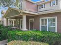 Welcoming home exterior showcasing a covered porch, detailed columns, and well-maintained green shrubbery at 6971 Tettenhall Ln, Windermere, FL 34786