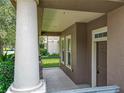 Exterior shot of a covered front porch with stone base columns, offering neighborhood views and easy access to the front door at 6971 Tettenhall Ln, Windermere, FL 34786
