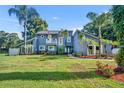 Charming two-story home featuring a well-manicured lawn and tropical landscaping at 7801 Georgeann St, Winter Park, FL 32792