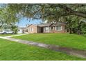 Inviting home with lush lawn, mature trees, and a comfortable, classic exterior at 8111 Esperanza St, Orlando, FL 32817