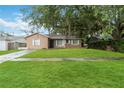 Single-story home with a well-kept lawn and mature trees, perfect for a cozy lifestyle at 8111 Esperanza St, Orlando, FL 32817