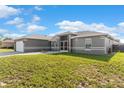 Charming single-story home featuring a gray exterior, well-manicured lawn, and an attached two-car garage at 906 Highland Crest Cir, Lake Wales, FL 33853
