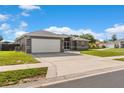 Charming single-story home featuring a gray exterior, well-manicured lawn, and an attached two-car garage at 906 Highland Crest Cir, Lake Wales, FL 33853