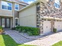 A two-story home features a three-car garage, stone accents, and fresh landscaping at 10319 Lavande Dr, Orlando, FL 32836