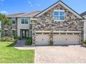Beautiful exterior features stone accents, a tile roof, and a brick driveway at 10319 Lavande Dr, Orlando, FL 32836