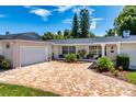 Charming home with a well-manicured front yard, brick driveway, and attached garage at 105 John Anderson Dr, Ormond Beach, FL 32176