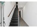 Modern hallway features sleek tile flooring and a stylish wooden staircase at 12468 Koshiba Aly, Orlando, FL 32827