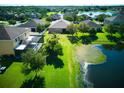 Aerial view of a house with a large backyard overlooking a scenic pond and lush landscaping at 12832 Sawgrass Pine Cir, Orlando, FL 32824