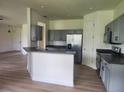 Bright kitchen featuring stainless steel appliances, gray cabinetry and stone countertops at 152 Glendale Ct, Kissimmee, FL 34759