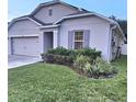 Single-story home with a well-manicured lawn and gray exterior with clean lines in a sunny neighborhood at 1588 Diamond Loop Drive, Kissimmee, FL 34744