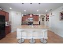 Open-concept kitchen with an island, pendant lighting, wood cabinets and stainless steel appliances at 1588 Diamond Loop Drive, Kissimmee, FL 34744
