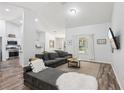 Spacious living room with a sectional sofa, hardwood floors, and a view of the adjacent kitchen at 15888 Ne 152Nd Ave, Fort Mc Coy, FL 32134