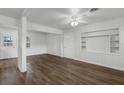 Spacious living area featuring wood-look flooring, white wainscoting, and a built-in shelving unit at 203 E Lakeview Ave, Eustis, FL 32726
