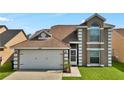 Close-up of a two-story home with a two-car garage and front lawn at 2235 Meadowmouse St, Orlando, FL 32837