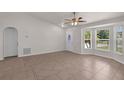 Open living area featuring tile flooring, a ceiling fan, and lots of natural light from the front windows at 253 Churchill Ct, Kissimmee, FL 34758