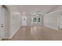 Spacious living area with ceramic tile flooring, white walls, and front door with decorative glass at 253 Churchill Ct, Kissimmee, FL 34758