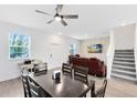 Open-concept living space with modern furnishings, a dining area, and access to the staircase, providing easy flow at 3099 Ella Way, St Cloud, FL 34771