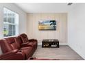 Inviting living room features a plush, reclining sofa, stylish accent wall, and modern decor that create a cozy and relaxing space at 3099 Ella Way, St Cloud, FL 34771