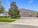 Charming single-story home with manicured lawn, lush landscaping and brick paved driveway at 31980 Geoff Way, Sorrento, FL 32776