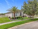 Charming single-story home with manicured lawn, lush landscaping and brick paved driveway at 31980 Geoff Way, Sorrento, FL 32776