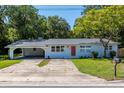 Charming single-story home featuring a covered carport and well-maintained lawn at 370 Hand Ave, Ormond Beach, FL 32174