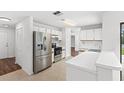 Bright, all-white kitchen with stainless steel appliances and modern fixtures at 400 Timbercreek N Dr, Winter Garden, FL 34787