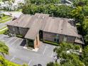 Aerial view of a multi-story condo building with brick and siding exterior, surrounded by lush greenery and ample parking at 538 W Par St # 538, Orlando, FL 32804