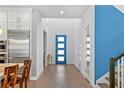 Bright foyer showcasing a modern blue door, sleek hardwood floors, and pristine white walls at 617 Worthington Dr, Winter Park, FL 32789