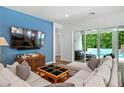 Comfortable living room with blue accent wall, plush seating, and sliding glass doors to the patio at 617 Worthington Dr, Winter Park, FL 32789